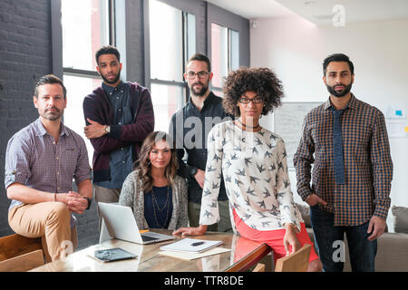 Portrait of business people at desk in office Stock Photo