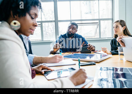 business people discussing over solar panel model in office Stock Photo