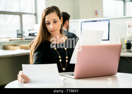 businesswoman reading document while working in office Stock Photo