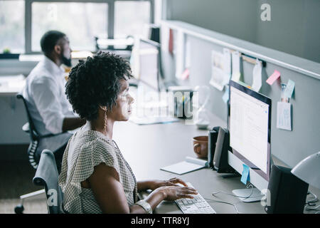 Side view of business people using desktop computers while working in office Stock Photo