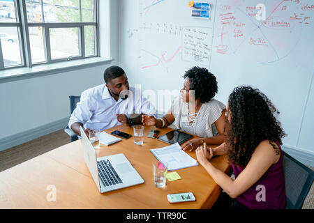 High angle view of business people discussing over laptop computer in board room at office Stock Photo