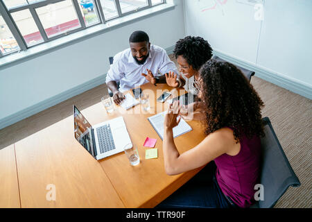 High angle view of business people discussing with businesswoman over video conference in board room Stock Photo