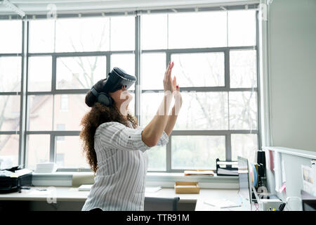 Businesswoman wearing virtual reality simulator in office Stock Photo