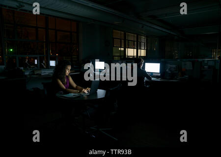 business people working in dark office at night Stock Photo