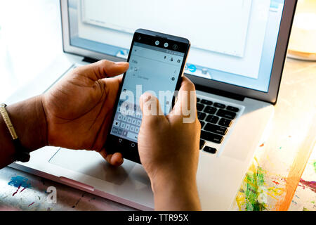 Cropped hands of businesswoman using smart phone Stock Photo