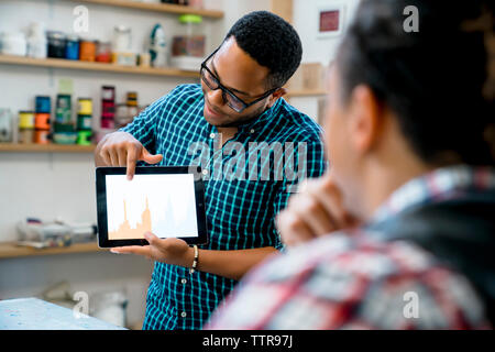 businessman showing graphs on tablet computer to male colleague Stock Photo