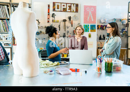 businesswomen discussing while standing by work bench Stock Photo