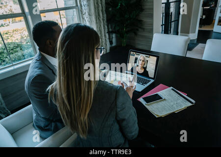 High angle view of business people video conferencing on laptop computer in office Stock Photo