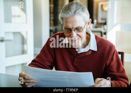 Senior man reading documents in financial advisor's office Stock Photo