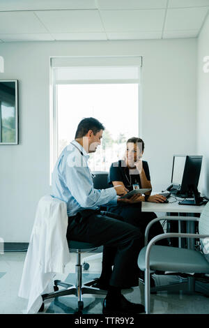 Doctors discussing over tablet computer in hospital Stock Photo