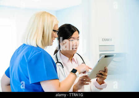Serious female doctors discussing over tablet computer in hospital Stock Photo