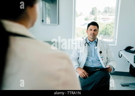 Doctor looking at female colleague while working in hospital Stock Photo