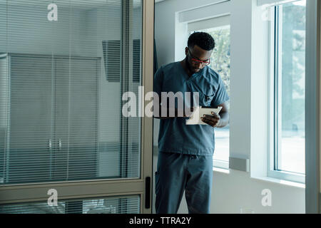 Doctor using tablet computer while working in hospital Stock Photo