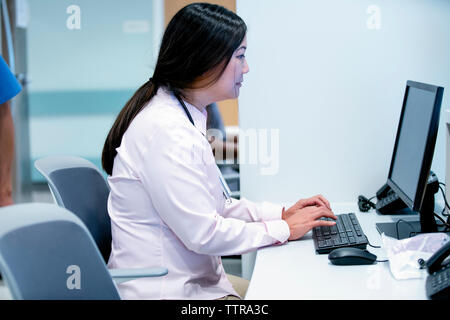 Side view of female doctor using desktop computer in hospital Stock Photo