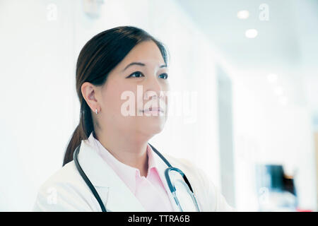 Thoughtful female doctor looking away in hospital Stock Photo