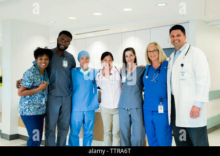 Portrait of cheerful doctors and nurses standing in hospital corridor Stock Photo