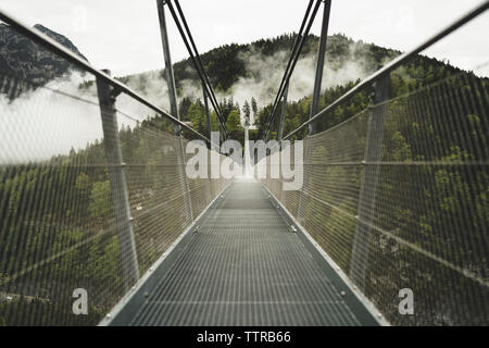 Diminishing perspective of Highline179 leading towards mountain against clear sky Stock Photo