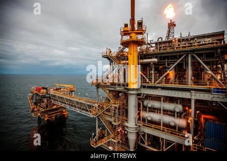 Oil rig in sea emitting fire Stock Photo
