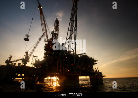 Low angle view of oil rig in sea against sky Stock Photo
