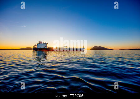 Ship in sea against blue sky during sunset Stock Photo