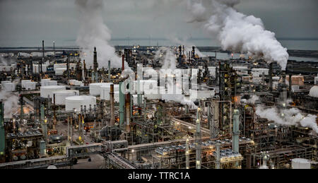 High angle view of oil refinery against cloudy sky during sunset Stock Photo