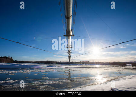 Low angle view of Trans-Alaskan Pipeline against sky during winter Stock Photo