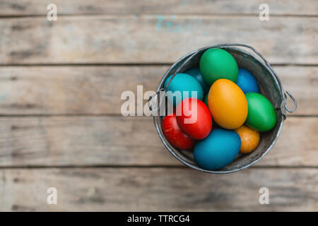 Overhead view of easter eggs in bucket on wooden table Stock Photo