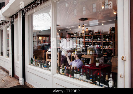 Multi-ethnic colleagues working in wine shop Stock Photo