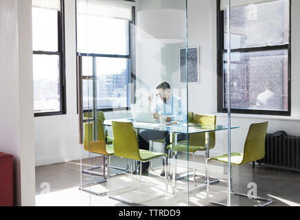 Creative businessman using laptop in board room Stock Photo