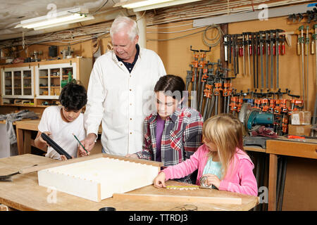 Carpenter teaching students in workshop