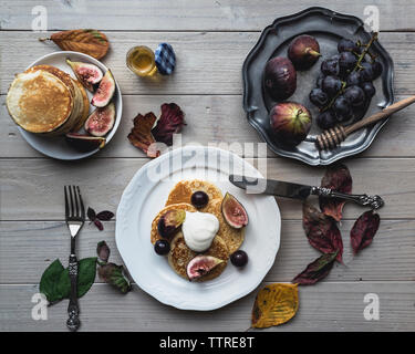 Overhead view of pancakes with figs and grapes on table Stock Photo