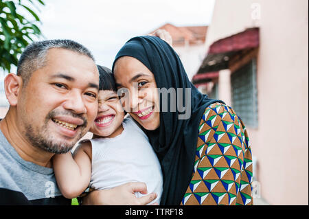 Portrait of happy family standing in backyard Stock Photo