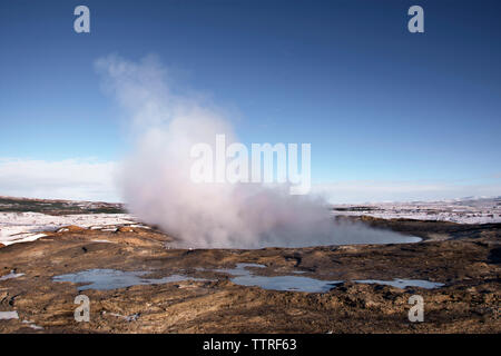 Steam coming out from geyser against clear blue sky Stock Photo