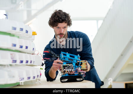 Low angle view of engineer making drone at table in office Stock Photo