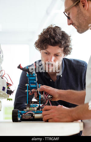 Engineers and technicians working together in a robotic arm factory ...