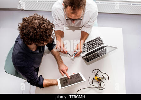 High angle view of engineers making drone at desk in office Stock Photo
