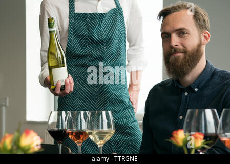 Midsection of bartender standing by customer in tasting room Stock Photo