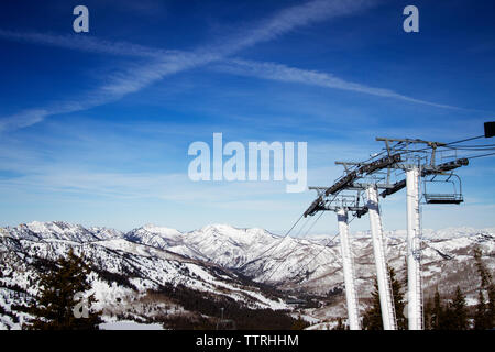 Ski lifts with snow covered Wasatch Mountain range in background Stock Photo