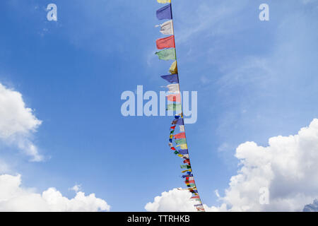 Low angle view of prayer flags against cloudy sky Stock Photo