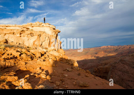 Distant view of female hiker standing on top of mountain Stock Photo