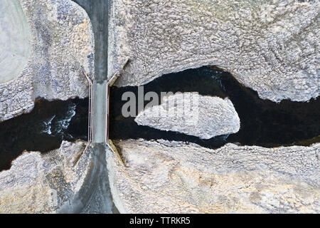 Drone view of asphalt route with bridge above water between wild lands Stock Photo