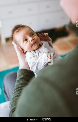 newborn baby girl in dad's arms making eye contact Stock Photo