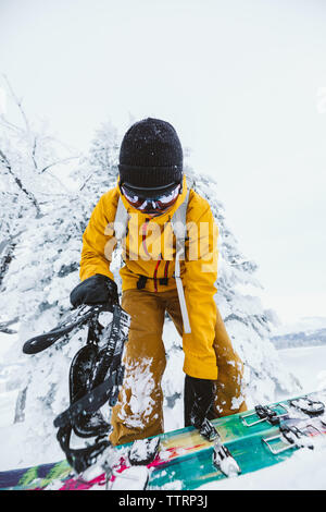 snowboarder in yellow jacket gets ready to shred in wyoming winter Stock Photo