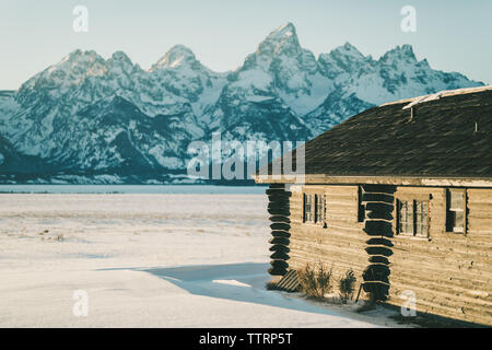 wyoming cabin in front of the tetons on a sunny winter day Stock Photo