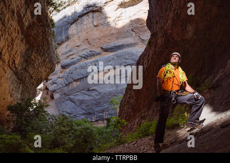 Male hiker standing in cave Stock Photo