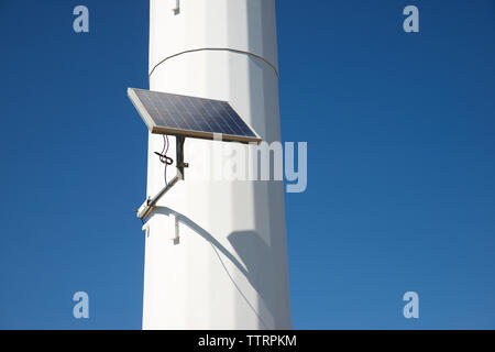 Low angle view of solar panel on Windmill against clear blue sky Stock Photo