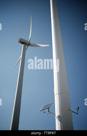 Low angle view of solar panel on Windmill against blue sky Stock Photo