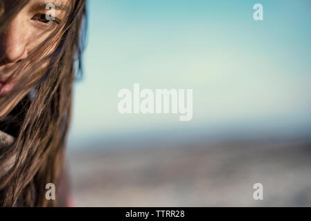 Cropped image of woman with tousled hair against sky Stock Photo