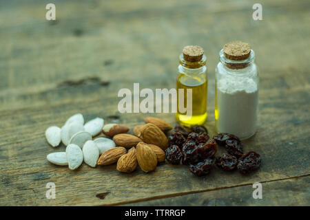 High angle view of various food with oil and ground in bottles on wooden table Stock Photo