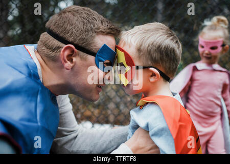 Father and boy in superhero costume with daughter Stock Photo